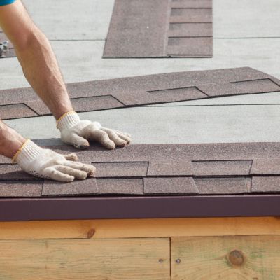 Roofer builder worker installing roof shingles