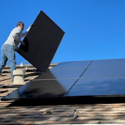 Worker installing solar panels on a roof